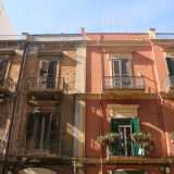 Foto 2. Siamo in via Quintino Sella, all�altezzza di via Principe Amedeo. Notiamo sin da subito un primo e caratteristico contrasto che ci accompagner� per tutto il resto del nostro viaggio. Si tratta di due edifici adiacenti praticamente uguali: ma mentre il primo, marroncino, appare quasi abbandonato, il secondo invece si presenta con un acceso e sfavillante color salmone e con dei fiori a ornare le ringhiere dei balconi 